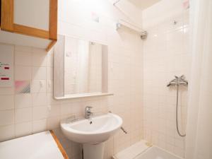a white bathroom with a sink and a shower at Apartment Les Lauzes-3 by Interhome in Les Menuires
