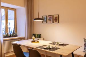 ein Esszimmer mit einem Tisch, Stühlen und einem Fenster in der Unterkunft Apartments Bären in Elzach