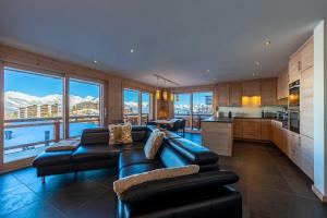 un soggiorno con divani e una cucina con montagne di Cordee 3 spa access a Nendaz
