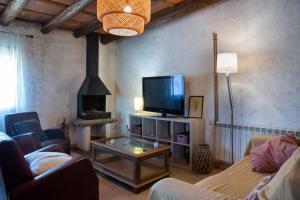 a living room with a tv and a fireplace at La Caseta del Mas Valls in Rupiá