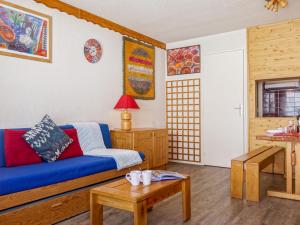 Studio Les Tommeuses - Val Claret-28 by Interhome في تينيِ: غرفة معيشة مع أريكة زرقاء وطاولة