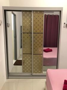 um quarto com um armário com um espelho e uma cama em CASA IDAMAN - Islamic Homez em Malaca