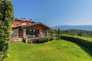 una casa su una collina con un giardino verde di Villa Valeria con piscina by Wonderful Italy a Toscolano Maderno
