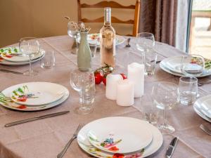 una mesa con platos blancos y copas de vino. en Holiday Home Kerdual by Interhome en La Trinité-sur-Mer