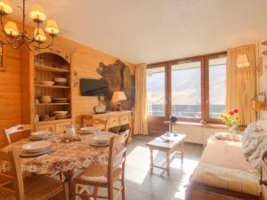a dining room with a table and a couch at Apartment Grandes Platières II-2 by Interhome in Tignes