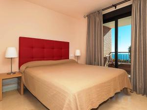 トロクス・コスタにあるApartment 3 bedrooms in Torrox Coast by Interhomeのベッドルーム1室(赤いヘッドボード付きの大型ベッド1台付)