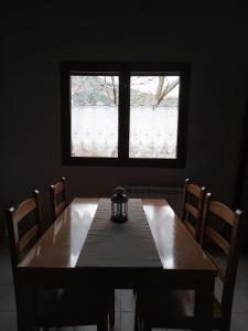 a dining room table with chairs and a window at Albergue de Liri in Lirí