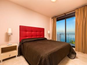 トロクス・コスタにあるApartment Amazing 2 bedrooms apartment by Interhomeのベッドルーム1室(赤いベッド1台、大きな窓付)