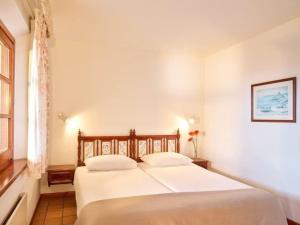 Castillo de AroにあるApartment Resort Hapimag Mas Nou by Interhomeのベッドルーム1室(白いシーツ付きのベッド1台、窓付)