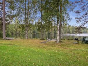 uma mesa de piquenique e um grelhador ao lado de um lago em Holiday Home Uitonniemi- rummukkala by Interhome em Polvijärvi