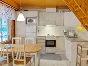 アカスロンポロにあるHoliday Home Ylläsröhkö d 8 by Interhomeのキッチン(白い家電製品、テーブル、椅子付)