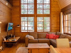 a living room with a couch and some windows at Holiday Home Kivalonmaa a by Interhome in Äkäslompolo