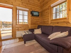 a living room with a couch in a log cabin at Holiday Home Joutsen by Interhome in Vähäsalmi