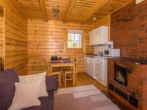 a living room with a kitchen and a table in a cabin at Holiday Home Joutsen by Interhome in Vähäsalmi