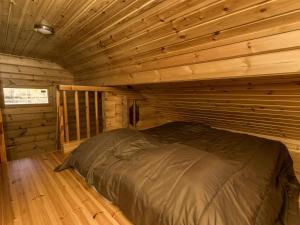 a bedroom in a log cabin with a bed at Holiday Home Joutsen by Interhome in Vähäsalmi