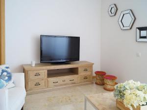 a living room with a television on a wooden cabinet at Apartment Lomas de Los Monteros by Interhome in Marbella