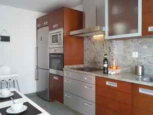 a kitchen with stainless steel appliances and wooden cabinets at Apartment Lomas de Los Monteros by Interhome in Marbella