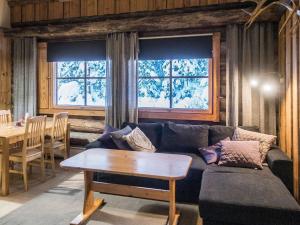 een woonkamer met een bank en een tafel bij Holiday Home Vuokatinportti a 12 by Interhome in Lahdenperä