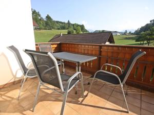 eine Terrasse mit Tisch und Stühlen auf einem Balkon in der Unterkunft Holiday Home Berg by Interhome in Obermieger