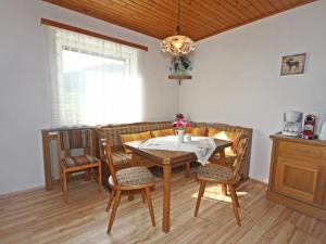 ein Esszimmer mit Tisch und Stühlen und einem Fenster in der Unterkunft Holiday Home Berg by Interhome in Obermieger