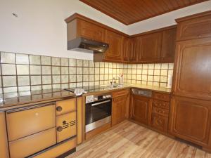 eine Küche mit Holzschränken und einem Herd mit Backofen in der Unterkunft Holiday Home Berg by Interhome in Obermieger