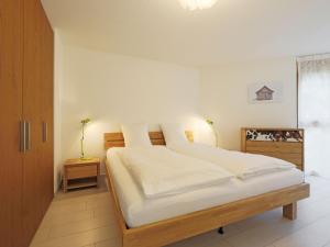 ein Schlafzimmer mit einem großen Bett mit weißer Bettwäsche in der Unterkunft Apartment Susanna by Interhome in Zermatt