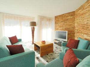 ein Wohnzimmer mit zwei blauen Sofas und einem TV in der Unterkunft Apartment Susanna by Interhome in Zermatt