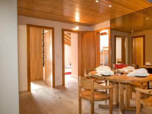 a dining room with a wooden table and chairs at Apartment Granit-5 by Interhome in Zermatt