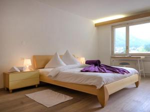 a bedroom with a bed with a purple blanket on it at Apartment Granit-5 by Interhome in Zermatt