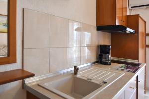 a kitchen with a sink and a microwave at Haus Despina in Sarti