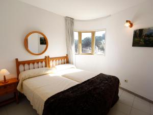 ビラフォルトゥニーにあるApartment Sol Daurat by Interhomeのベッドルーム1室(ベッド2台、鏡、窓付)