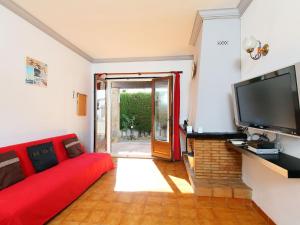 レスカラにあるHoliday Home La Masia by Interhomeのリビングルーム(赤いソファ、薄型テレビ付)