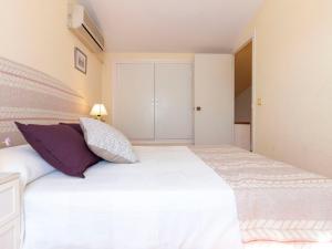 リウマルにあるHoliday Home Salvagina by Interhomeのベッドルーム(紫色の枕が付いた大きな白いベッド付)