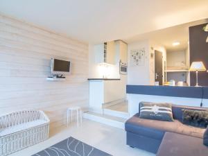 a living room with a couch and a tv at Studio Les Marinas-10 by Interhome in Deauville