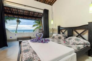 a bedroom with a bed with a view of the ocean at Pousada Aguas Marinhas in Cabo de Santo Agostinho