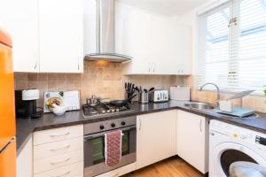 a kitchen with a stove and a dishwasher at 14 Tivoli Mews in Cheltenham