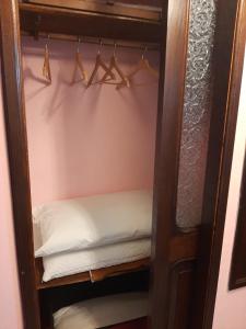 un armadio con grucce e un letto in esso di Les Jeux Sont Faits a Napoli