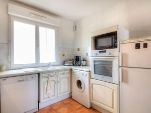 a kitchen with a washer and dryer and a window at Apartment les Terrasses du Cap by Interhome in Capbreton