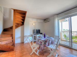 a dining room with a table and a balcony at Apartment les Terrasses du Cap by Interhome in Capbreton