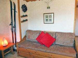 レ・メニュアールにあるApartment L'Oisans by Interhomeのリビングルーム(赤い枕2つ付きのソファ付)