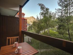 a balcony with a table and a view of a mountain at Apartment Pegase Phenix-65 by Interhome in Le Corbier