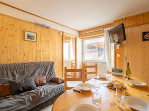 uma sala de estar com um sofá e uma mesa de madeira em Apartment Les Lauzes-5 by Interhome em Les Menuires