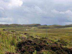 a field of grass with a road in the distance at Holiday Home Flo Anndra by Interhome in Kilmaluag