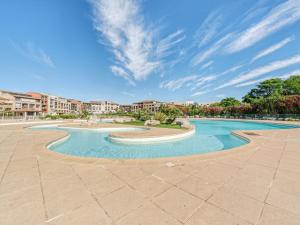 ein Pool in einem Resort unter blauem Himmel in der Unterkunft Apartment Les Marines-41 by Interhome in La Foux