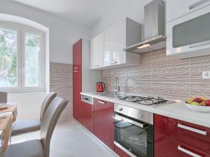 a kitchen with red and white cabinets and a sink at Holiday Home More by Interhome in Trget