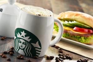 eine Tasse Kaffee und ein Sandwich auf dem Tisch in der Unterkunft SMARTY Cologne Dom Hotel - Boardinghouse - KONTAKTLOSER SELF CHECK-IN in Köln + 58 Fotos