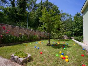 une cour pleine de balles sur l'herbe avec un arbre dans l'établissement Holiday Home Luna by Interhome, à Kamenmost