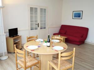 sala de estar con mesa y sofá rojo en Apartment Le Petit Robinson-4 by Interhome, en La Richardais