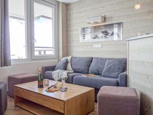 uma sala de estar com um sofá azul e uma mesa em Apartment Le Curling B - Val Claret-35 by Interhome em Tignes