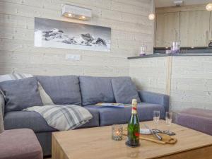 a living room with a blue couch and a table at Apartment Le Curling B - Val Claret-35 by Interhome in Tignes